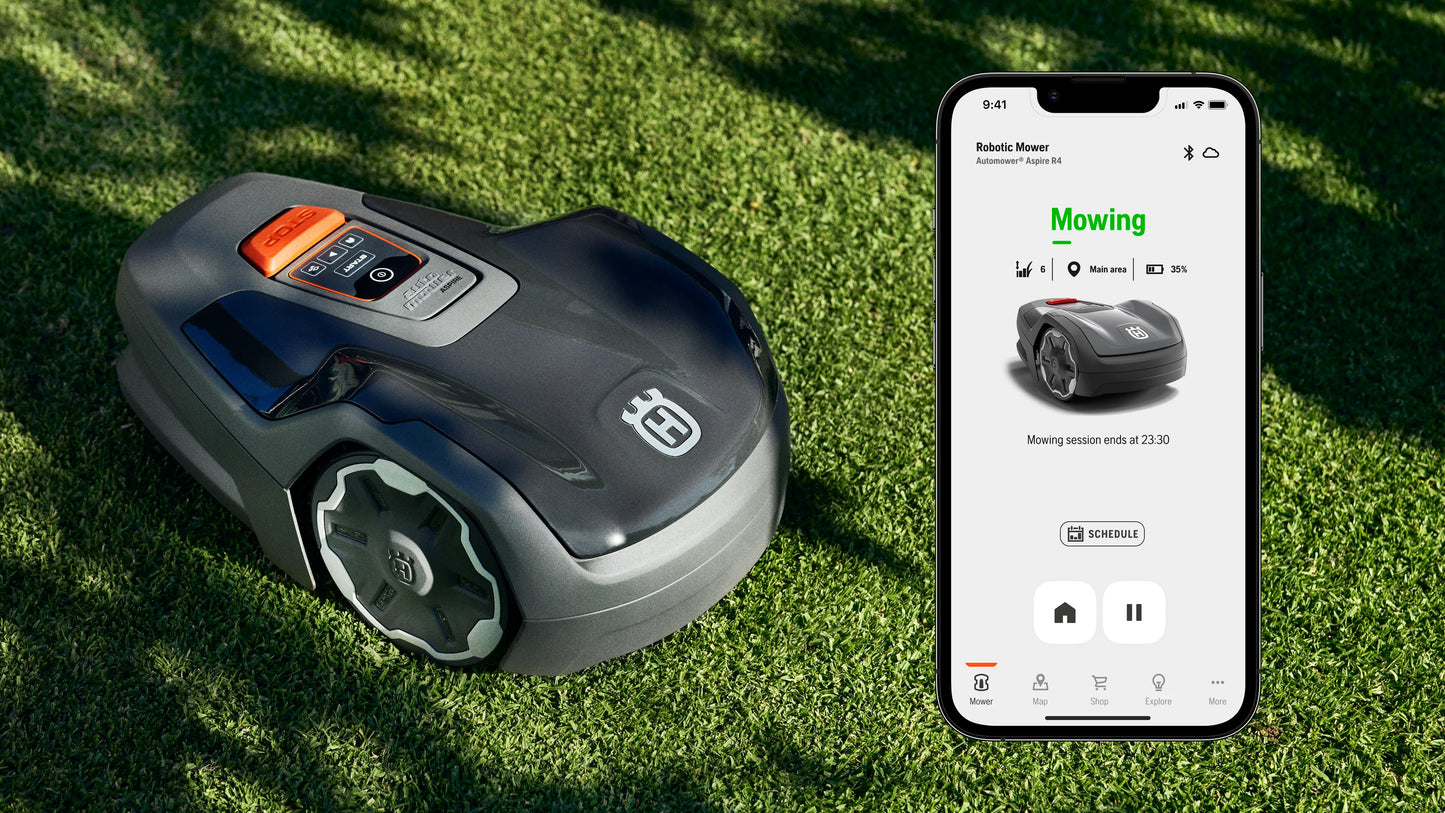 Husqvarna Aspire R4 robotic lawn mower on grass with smartphone displaying app interface