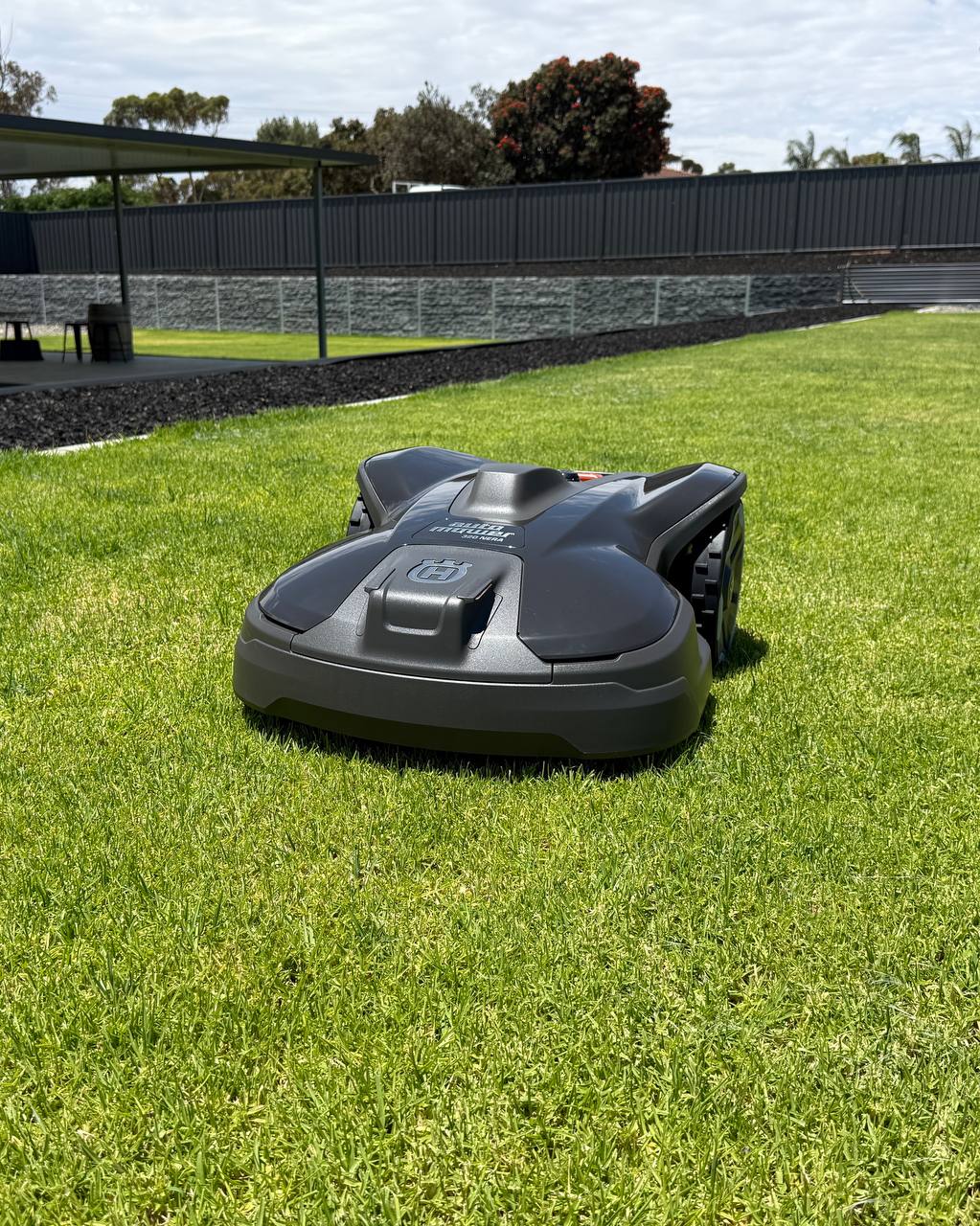 Husqvarna Automower 320 NERA on a grassy area with a fence and trees in the background in Murray Bridge-South Australia-2