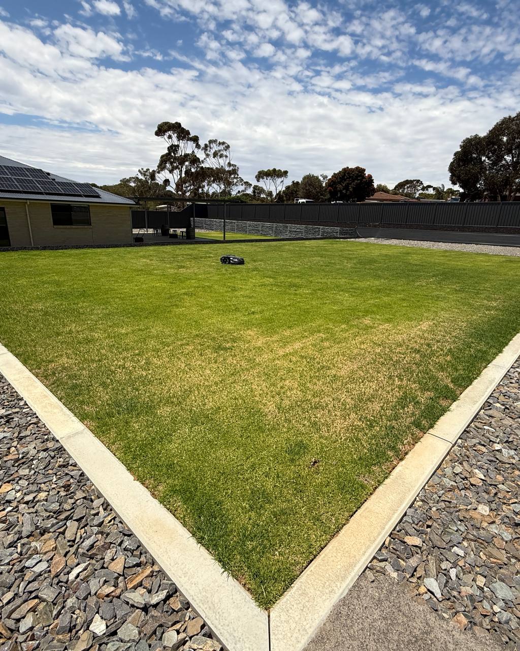 Lawn with a patch of brown grass in a residential area with Husqvarna Automower 320 Nera