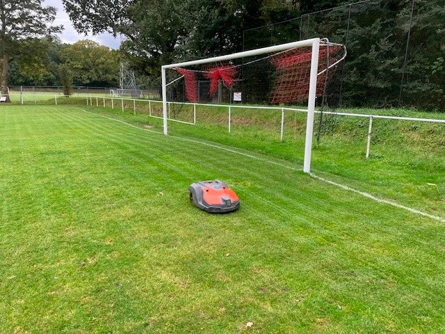 Automower 550 EPOS commercial Robotic lawn mower on a grassy field with a soccer goal in the background