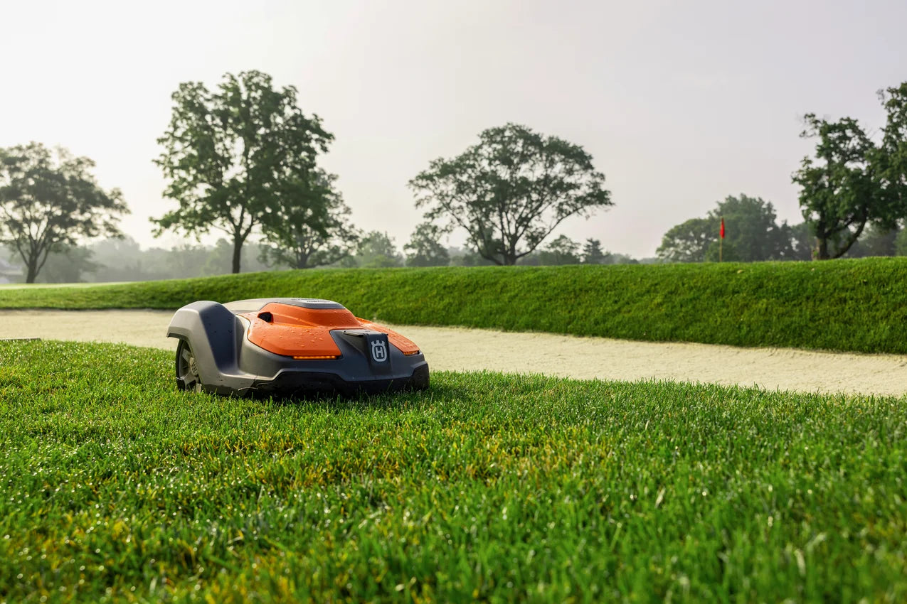 Automower 550 EPOS Commercial Robotic lawn mower on a well-maintained lawn with trees in the background