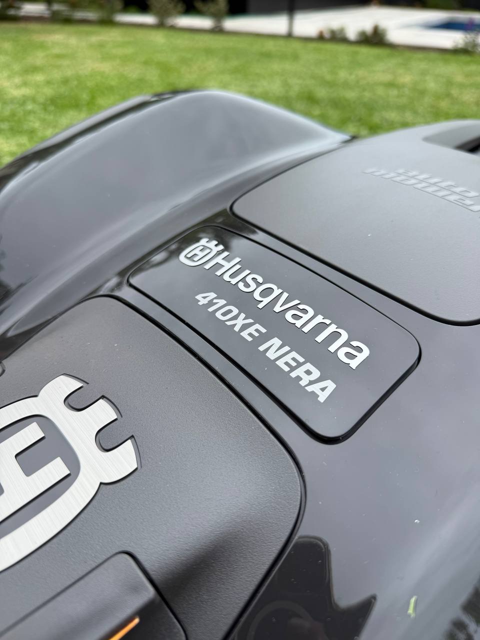 Close-up of a Husqvarna 410XE NERA lawn mower with branding.