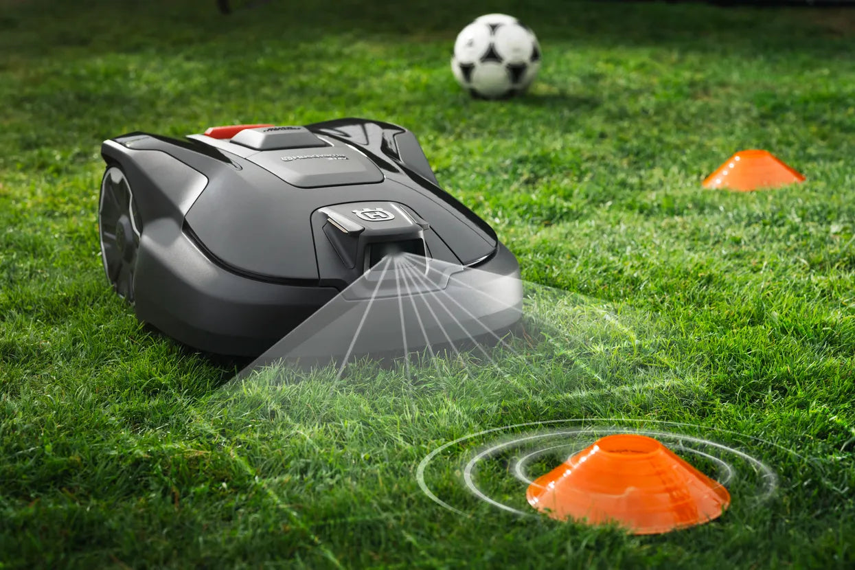 Automower 312V Husqvarna 970 83 11-06 on grass with soccer ball and orange cones in the background