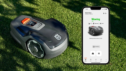 Husqvarna Aspire R4 robotic lawn mower on grass with smartphone displaying app interface