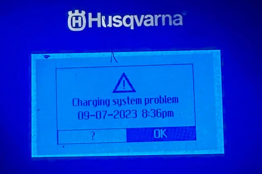 Husqvarna Automower screen displaying 'Charging system problem' message with date and time.
