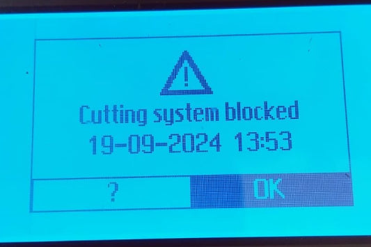 Automower warning message on a screen indicating 'Cutting system blocked' with a timestamp.